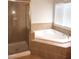 Bright bathroom featuring glass shower and large tub under the window at 3123 Hudson Hill Ln, Raleigh, NC 27612