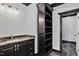 Bathroom with granite counter tops, dark cabinets, built-in shelving, and modern lighting at 318 W Lillington St, Angier, NC 27501