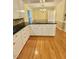 Kitchen featuring hardwood floors, white cabinets, and black countertops/backsplash at 325 Old Salem Rd, Roxboro, NC 27573