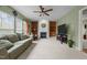 Cozy living room featuring a fireplace with decorative accents, complemented by a ceiling fan and natural light at 401 Euphoria Cir, Cary, NC 27519