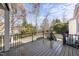 The wooden back deck features black metal railing with wooded view beyond the back yard at 405 Chandler Grant Dr, Cary, NC 27519