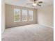 Large carpeted bedroom with three windows providing ample natural light, and a ceiling fan at 4909 Jelynn St, Raleigh, NC 27616
