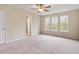 Spacious bedroom with carpet flooring and a ceiling fan, complemented by three bright windows at 4909 Jelynn St, Raleigh, NC 27616