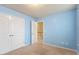 Bedroom featuring blue walls, carpeted floor, a ceiling light, and double closet at 4909 Jelynn St, Raleigh, NC 27616