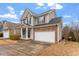 Traditional home with a covered front porch, two-car garage, and brick and gray siding exterior at 4909 Jelynn St, Raleigh, NC 27616