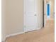Hallway with a view to an open doorway, a closed bedroom door and neutral carpet at 4909 Jelynn St, Raleigh, NC 27616