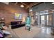 Spacious living room with brick wall, wood ceiling, concrete flooring, and modern furnishings at 500 N Duke St # 55-103, Durham, NC 27701
