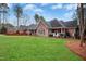 Expansive backyard with lush green lawn, mature trees, and beautiful brick home at 5204 Winter Holly Ct, Raleigh, NC 27606