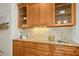 Entertainer's bar with decorative glass cabinets, a tile backsplash, and granite countertop at 5204 Winter Holly Ct, Raleigh, NC 27606