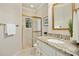 Well-lit bathroom features a tiled shower, gold fixtures, granite countertops, and a gold framed mirror at 5204 Winter Holly Ct, Raleigh, NC 27606