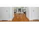 Hallway view shows hardwood floors leading to living room with fireplace and grey sofas at 5204 Winter Holly Ct, Raleigh, NC 27606