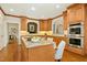 Elegant kitchen with wood cabinets, double ovens, granite counters and central island with cooktop at 5204 Winter Holly Ct, Raleigh, NC 27606