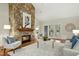 Open-concept living room with stone fireplace, hardwood floors, and views of the backyard at 5204 Winter Holly Ct, Raleigh, NC 27606