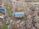 An aerial shot showcasing a home with driveway, siding and gray roof with a well manicured lawn surrounded by trees at 5512 Spring Bluffs Ln, Raleigh, NC 27606