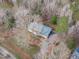Aerial view of a well-maintained home nestled in a wooded area, featuring a driveway and lush greenery at 5512 Spring Bluffs Ln, Raleigh, NC 27606