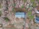 An aerial view of a house with a gray roof, nestled among trees, showcasing its secluded location and long driveway at 5512 Spring Bluffs Ln, Raleigh, NC 27606