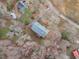 Aerial view of a home with blue roof, surrounded by trees, along with a paved driveway and other homes nearby at 5512 Spring Bluffs Ln, Raleigh, NC 27606