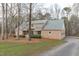Brick home with a side-entry garage and a well-manicured lawn, nestled among mature trees at 5512 Spring Bluffs Ln, Raleigh, NC 27606