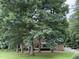 Picturesque brick home surrounded by lush trees, enhancing its curb appeal and privacy at 5512 Spring Bluffs Ln, Raleigh, NC 27606