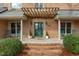 Inviting front porch with a pergola, rocking chairs, and manicured landscaping at 5512 Spring Bluffs Ln, Raleigh, NC 27606