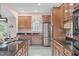 Spacious kitchen with wooden cabinets, granite countertops, stainless steel appliances, and a view to the trees outside at 5512 Spring Bluffs Ln, Raleigh, NC 27606