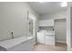Bright laundry room featuring a washer, dryer, and built-in storage, conveniently located next to a freezer at 5512 Spring Bluffs Ln, Raleigh, NC 27606