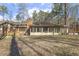 Home exterior back featuring a sunroom addition and large yard with mature trees at 6065 Merion Cir, Sanford, NC 27332