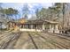 Exterior back view of home with a sunroom featuring a back deck and large yard at 6065 Merion Cir, Sanford, NC 27332