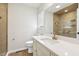 Bright bathroom featuring vanity with marble top, gold hardware, and tiled walk-in shower at 6065 Merion Cir, Sanford, NC 27332