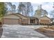 Lovely brick home featuring a well-kept lawn, mature trees, and an expansive concrete driveway at 6065 Merion Cir, Sanford, NC 27332