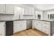 Bright kitchen features white cabinets, stainless steel dishwasher, and eye-catching backsplash at 6065 Merion Cir, Sanford, NC 27332
