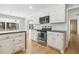 Stylish kitchen with modern appliances, granite countertops and white cabinetry with a view into the living room at 6065 Merion Cir, Sanford, NC 27332