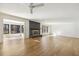 Bright living room featuring hardwood floors, a brick fireplace, and large windows for plenty of natural light at 6065 Merion Cir, Sanford, NC 27332