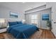 This decorated bedroom features hardwood floors, a plush bed, and ocean-themed wall art for a relaxing atmosphere at 638 Village Lake Dr, Mebane, NC 27302