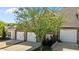 Townhouse featuring a brick facade, two-car garage, landscaping, and a mature tree at 638 Village Lake Dr, Mebane, NC 27302
