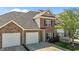 Charming two-story brick townhouse featuring a two-car garage, black shutters, and landscaped yard at 638 Village Lake Dr, Mebane, NC 27302