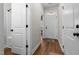 Hallway featuring wood floors, white doors, trim and neutral walls at 638 Village Lake Dr, Mebane, NC 27302
