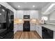 Kitchen features granite counters, black appliances, mosaic backsplash, white cabinets, and wood flooring at 638 Village Lake Dr, Mebane, NC 27302