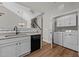 Bright kitchenette with white cabinets, granite countertops, black appliances, and a washer and dryer at 638 Village Lake Dr, Mebane, NC 27302