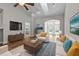Bright living room featuring hardwood floors, large windows, and stylish furniture at 638 Village Lake Dr, Mebane, NC 27302