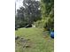 Backyard is a spacious lawn with mature trees, ready for landscaping or recreational use at 652 Old Sanford Rd, Moncure, NC 27559