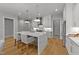 Bright kitchen boasts a waterfall island, pendant lighting, stainless steel appliances, and sleek white cabinets at 809 Tower St, Raleigh, NC 27607