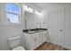 Bright bathroom featuring double vanity, wood-look floors, and a toilet at 962 Spring Hill Church Rd, Lillington, NC 27546