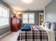 This bedroom features carpet flooring, a red cabinet, and two windows with blinds at 1000 Eastham Dr, Apex, NC 27502