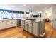 Open concept kitchen with island cooktop and hardwood floors flowing into the living area at 1000 Eastham Dr, Apex, NC 27502