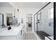Luxurious bathroom featuring double vanity, walk-in closet, and glass-enclosed shower with sleek black fixtures at 1005 Whistler St, Durham, NC 27713