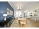 Open-concept dining area with a blue accent wall, modern lighting, and seamless flow to the adjacent kitchen at 1005 Whistler St, Durham, NC 27713