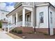 Charming front porch with white columns, stairs, railings and brick facade, enhancing curb appeal at 1005 Whistler St, Durham, NC 27713