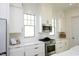 Bright kitchen featuring white cabinetry, stainless steel appliances, gas range, and subway tile backsplash at 1005 Whistler St, Durham, NC 27713