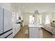 Modern kitchen featuring white cabinets, stainless steel appliances, a center island with seating, and an open layout at 1005 Whistler St, Durham, NC 27713